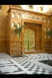 Bringing royal heritage to life: A stunning custom glass inlay tree of life mural set against majestic stone architecture and a classic checkered courtyard